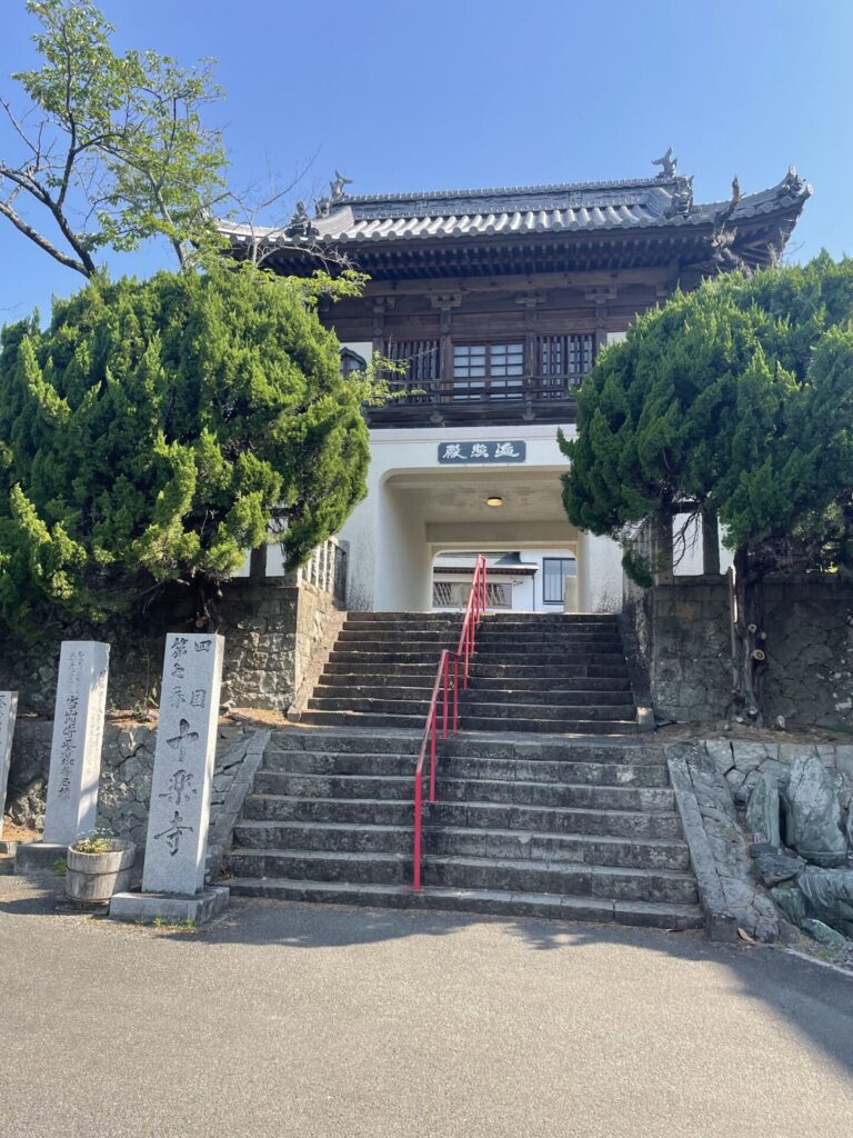 『遍照殿』の額がかかる門。赤い手すりの階段を上って参拝する。